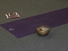 purple yoga mat with singing bowl